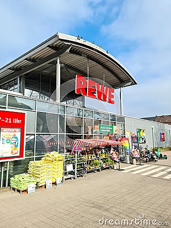Entrance of a REWE supermarket in Germany in sunny weather Editorial Stock Photo