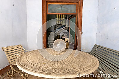 Entrance with round table of an abandoned villa in the Italian countryside. Urbex Editorial Stock Photo