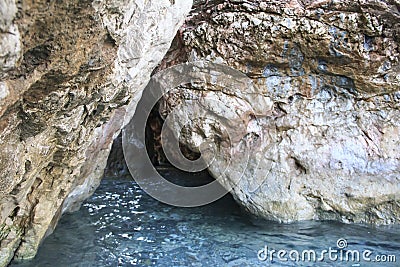 The entrance to the coastal cave. Rocks Stock Photo