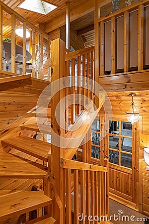 Entrance to a completely wooden house. Door, railings and bright lamps in a small country house. Stock Photo