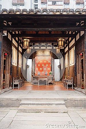 Entrance to an ornate traditional Chinese building with an intricate rug hung on the inside wall Stock Photo