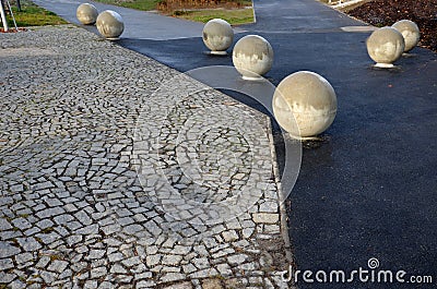 The entrance to the park is secured against the entry of cars by placing concrete balls attached to the paving or asphalt. protect Stock Photo