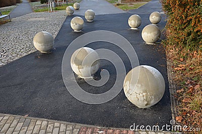 The entrance to the park is secured against the entry of cars by placing concrete balls attached to the paving or asphalt. protect Stock Photo