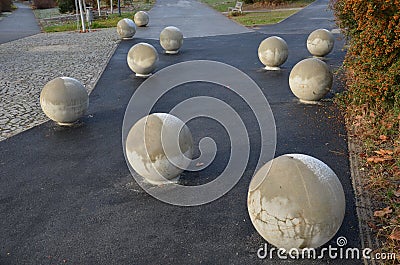 The entrance to the park is secured against the entry of cars by placing concrete balls attached to the paving or asphalt. protect Stock Photo