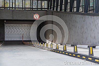 Entrance to underground car park with roller-shutter door and road dividers Stock Photo