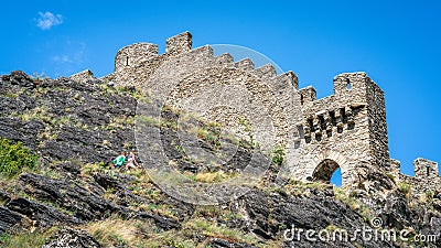 Entrance and wall of the ruins of Tourbillon castle with tourist going up the hill in Sion Switzerland Stock Photo