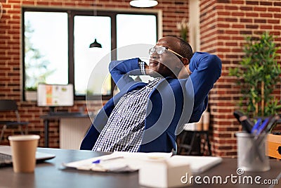 Entrepreneur relaxing after finishing work, taking break in company office Stock Photo