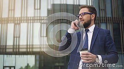 Entrepreneur réussi parlant au téléphone, café potable se tenant sur la rue de ville banque de vidéos Entrepreneur réussi parlant au téléphone, café potable se tenant sur la rue de ville banque de vidéos