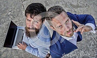 Entrepreneurship as teamwork. Businessmen with laptop and phone call solving problems making deal. Stock Photo