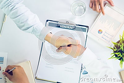 Entrepreneurship new business start up meeting. Close up hand of young asian businessman shaking over contract document. Stock Photo