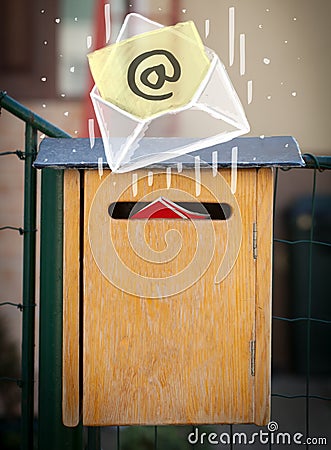 Envelope with email sign dropping into mailbox Stock Photo