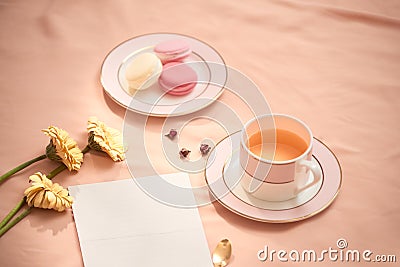 Envelope, flowers, and macarons with cup of tea Stock Photo