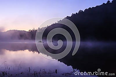 Environmental Friendly Outdoor Activity, Floating Bamboo Rafting in the morning in serene lake with sunlight and mist water Stock Photo