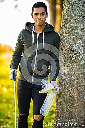 Environmental protection volunteer holding garbage and mechanical grabber Stock Photo