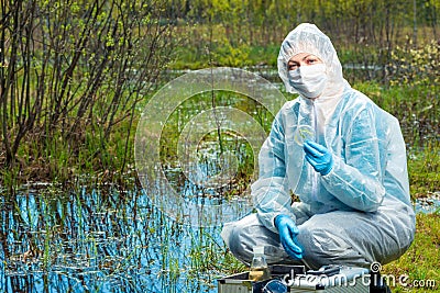 environmentalist chemist with samples of water and plants from the forest river conducts Stock Photo