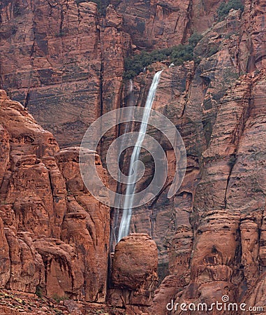 Ephemeral waterfall cascading down red sandstone cliffs in Southern Utah, USA Stock Photo