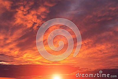 Epic dramatic sunset, sunrise red orange sky with mammatus clouds, sun and sunlight Stock Photo