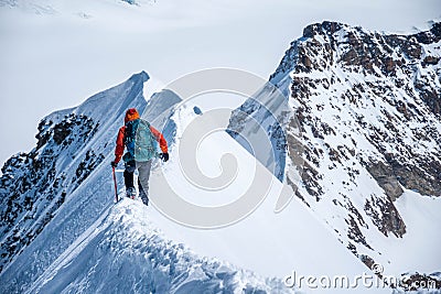 Epic view on descending alpinist on a steep narrow snow ridge, extreme climbing mountaineer, Monch, Bernese Alps, Swiss Stock Photo