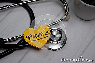 Epigenetics write on sticky note isolated on wooden table. Medical concept Stock Photo