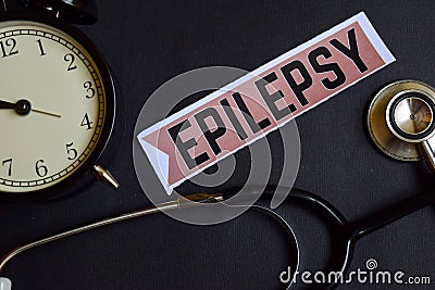 Epilepsy on the print paper with Healthcare Concept Inspiration. alarm clock, Black stethoscope. Stock Photo