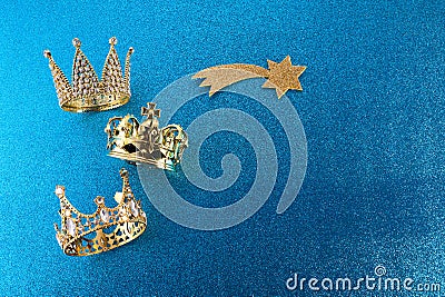 Epiphany Day or Dia de Reyes Magos concept. Three gold crowns on blue sparkling background Stock Photo