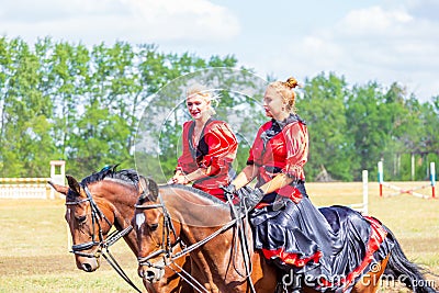 Equestrian sport dressage, passage - two young girls in beautiful clothes sit on a horse Editorial Stock Photo
