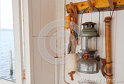 Old Vintage oil lamp hanging on the wall of fisherman beach house Stock Photo