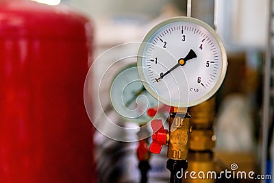 The equipment of the boiler-house, - valves, tubes, pressure gauges, thermometer. Close up of manometer, pipe, flow meter, water Stock Photo