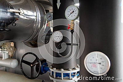 The equipment of the boiler-house, - valves, tubes, pressure gauges, thermometer. Close up of manometer, pipe, flow meter, water Stock Photo