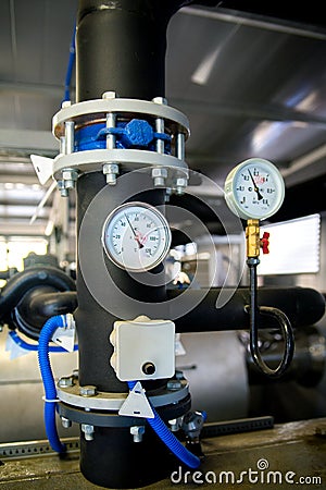 The equipment of the boiler-house, valves, tubes, pressure gauges, thermometer. Close up of manometer, pipe, flow meter, water Stock Photo