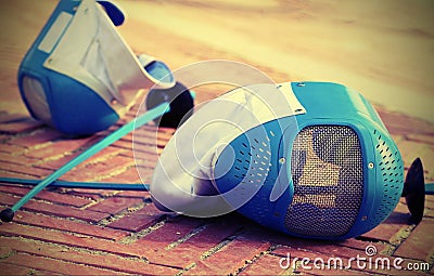 Equipment fencing mask and foil resting on the ground after the Stock Photo