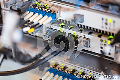 Equipment of radio base station close-up, blue and yellow optic patch cords. Internet. Communication. Network Stock Photo