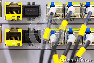 Equipment of radio base station close-up, blue and yellow optic patch cords. Stock Photo
