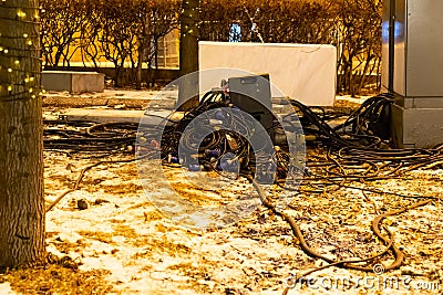 Equipment wiring electricity distribution organizing a street party fair. Fair Lighting Pile Wire Generator Stock Photo