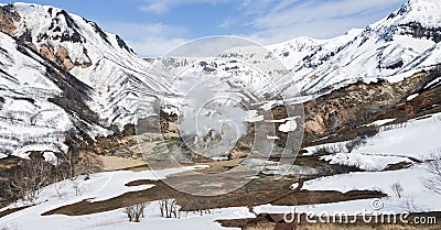 Equipped ecological trail and bear tracks in the snow in the Valley of Geysers in Kamchatka Stock Photo