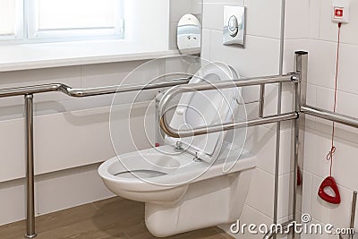 Equipped toilet room for the elderly, invalides and low-mobility people in a public place. SOS staff call handlers Stock Photo