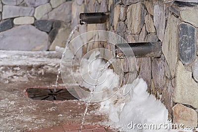 Equipped water source with the withdrawal of metal pipes with drinking water to the surface. Winter, frost. Stock Photo