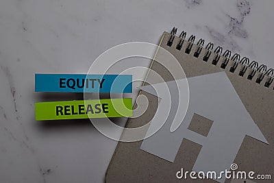 Equity Release write on sticky note and house made from paper isolated on Office Desk. Retirement concept Stock Photo