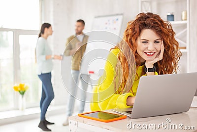 Jolly female employee working with laptop Stock Photo