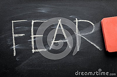 Erasing fear, hand written word on blackboard being erased Stock Photo