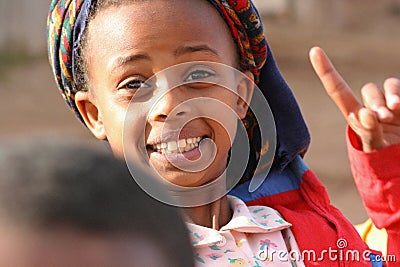 An Eritrean girl makes the sign with her index finger and looks towards the camera, on the outskirts of Asmara, Eritrea. Editorial Stock Photo