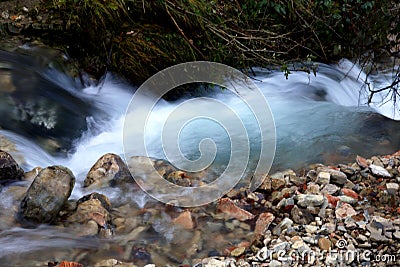 Stretch of blurred motion of the stream with small waterfalls, in the bottleneck among the fractured rocks Stock Photo