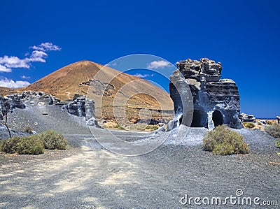 Erosion weathering blue rock formations Plano de El Mojon against the background of a volcanic cone, blue sky Stock Photo