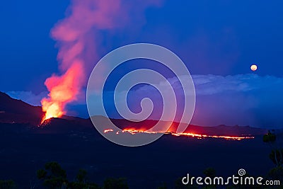 Errupting volcano in moonlit blue nightsky Stock Photo