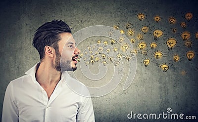 Erudite man talking spreading smart ideas with light bulbs coming out of his mouth Stock Photo