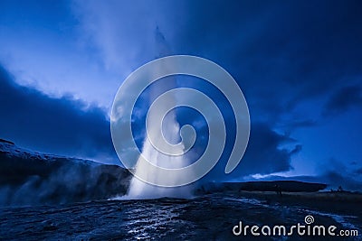 Eruption of Strokkur geyser in Iceland. Winter cold colors, moon lighting through night Stock Photo