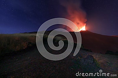 Panoramica del vulcano di Sicilia: Etna in eruzione durante la notte con sfondo il cielo stellato Stock Photo