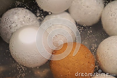 Bubbling water jostles brown and white eggs in boil Stock Photo