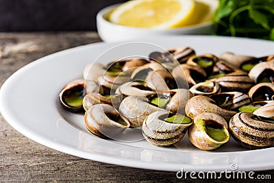 Escargots de Bourgogne. Snails with herbs and garlic butter on a plate. Stock Photo