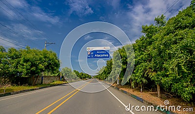 Esmeraldas, Ecuador - March 16, 2016: Paved road in the coast, with informative sign, surrounded with abundat vegetation Editorial Stock Photo